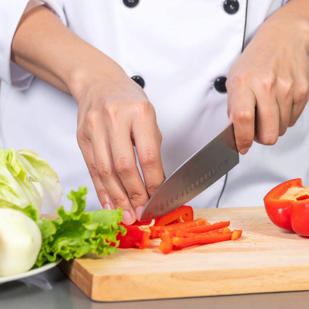 A chef slicing a red capsicum