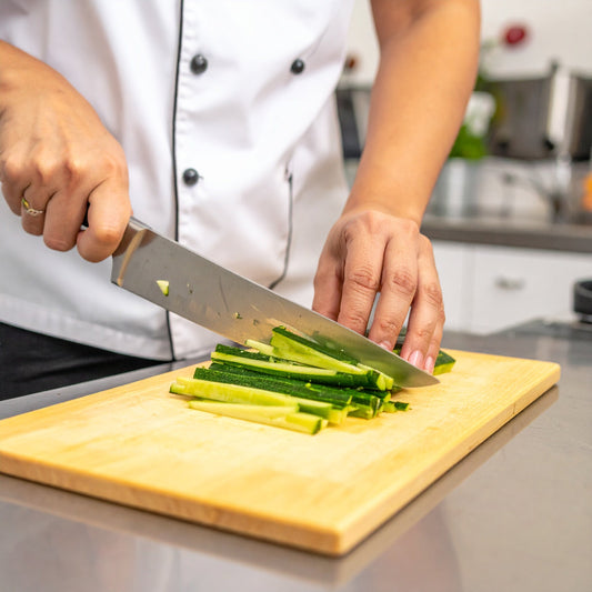 Chef cutting courgette batons on a chopping board