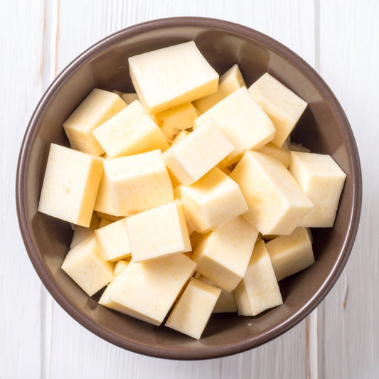 Diced Parsnip in a brown bowl on a wooden table