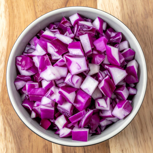 Diced Red Cabbage in a bowl on a wooden table