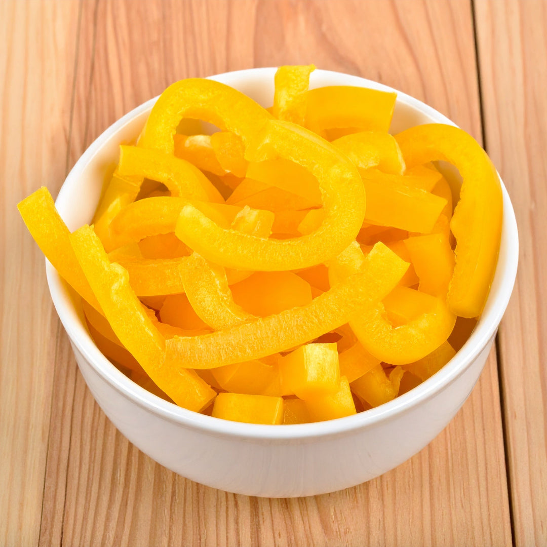 Sliced Yellow Capsicum in a white bowl on a wooden table