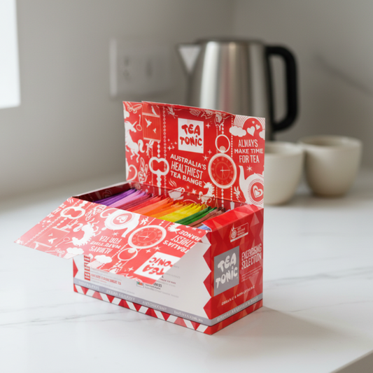 Open box of Tea Tonic tea bags with colorful packaging on a white background